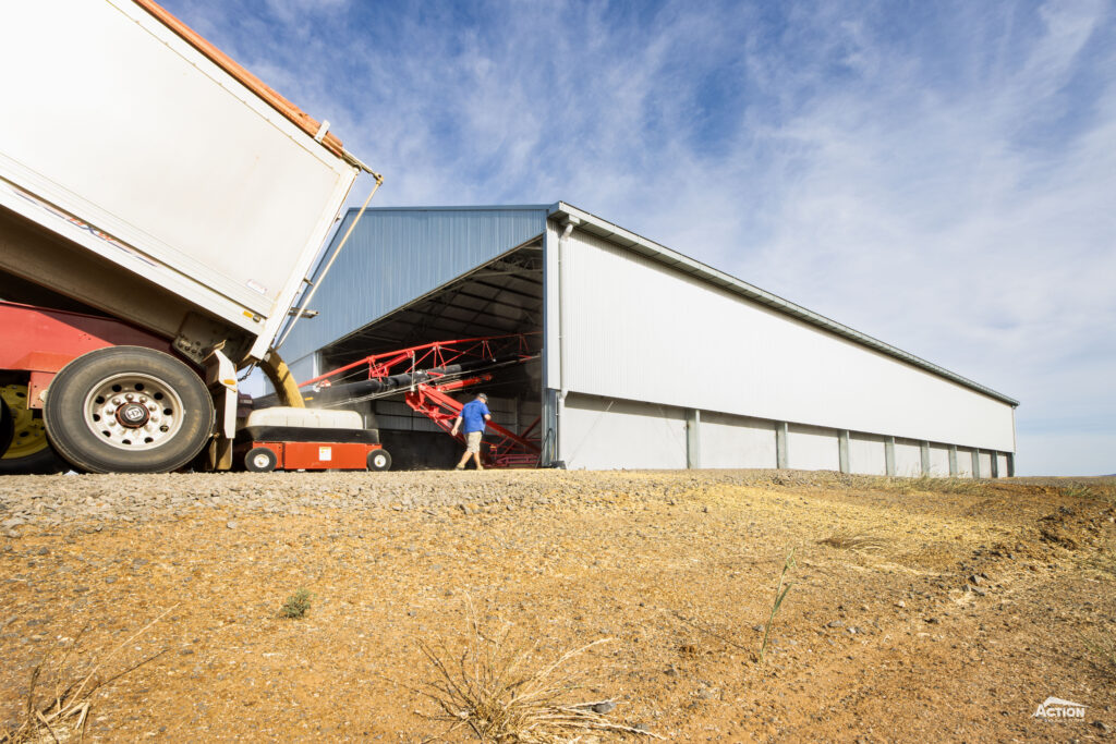 Grain shed loading method truck tipping into auger